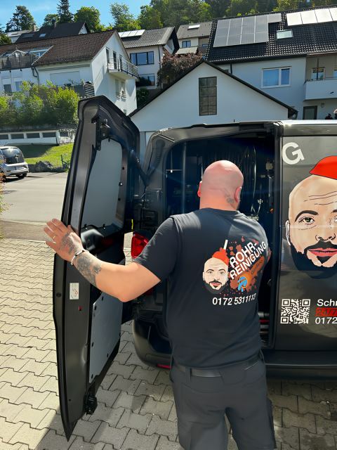 Rohrreiniger holt Ausrüstung aus dem Einsatzfahrzeug