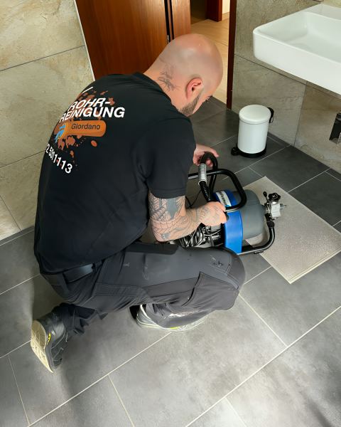 Rohrreinigung mit motorbetriebener Spirale im Bad