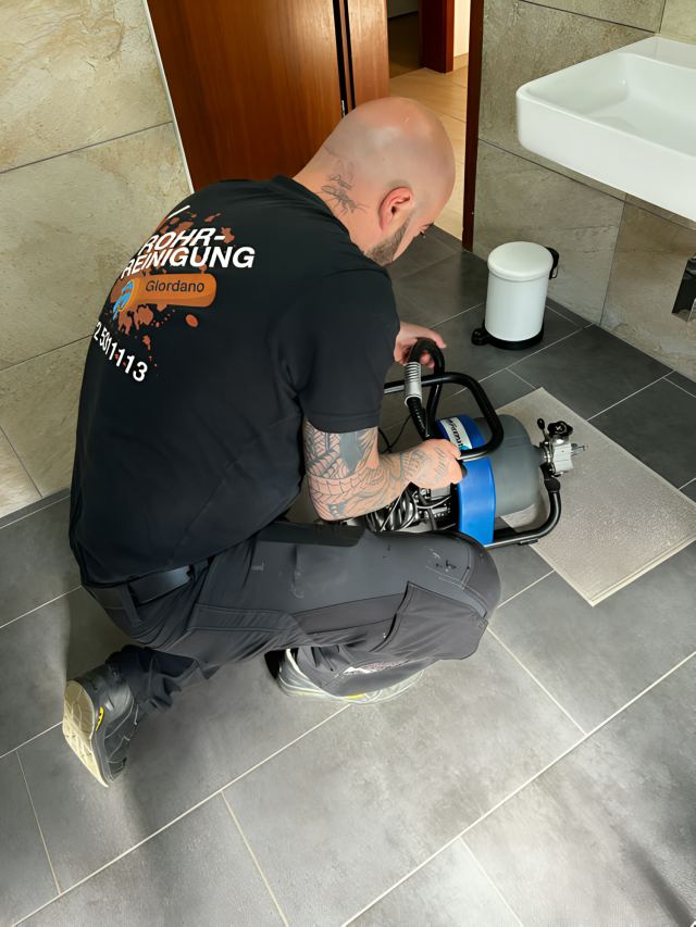 Rohrreinigung mit motorbetriebener Spirale im Bad