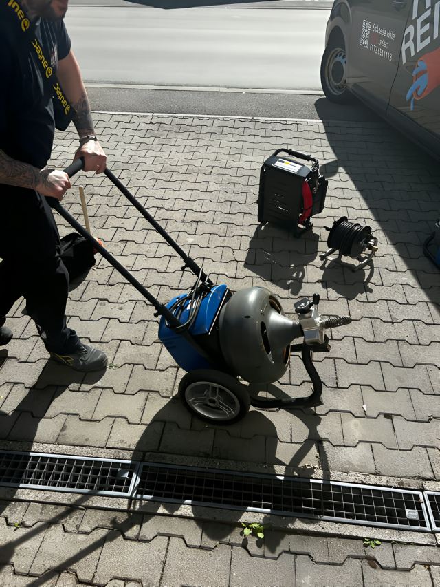 Spiralmaschine an einer Entwässerungsrinne in der Einfahrt